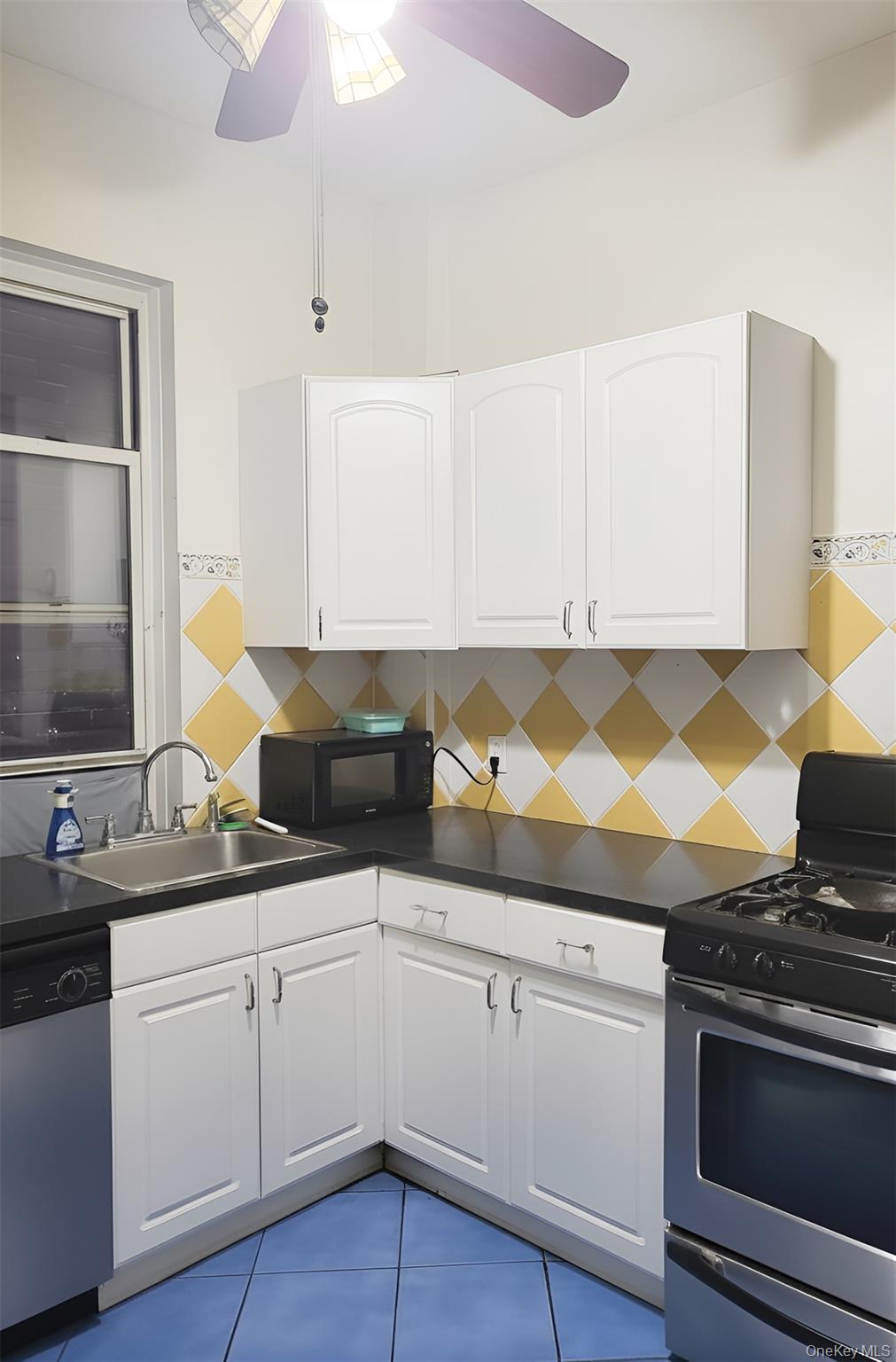 324 East 50th Street, Unit 3A Manhattan, NY 10022 - Photo 8 of 13 a kitchen with granite countertop a sink and a stove