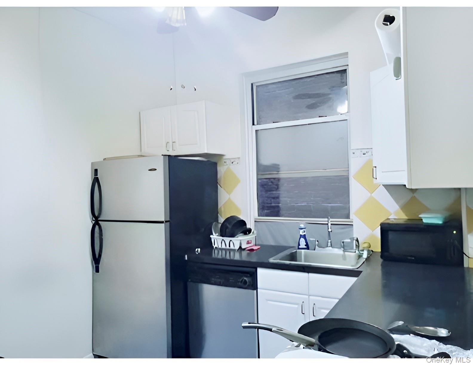 324 East 50th Street, Unit 3A Manhattan, NY 10022 - Photo 9 of 13 a kitchen with a refrigerator and a sink
