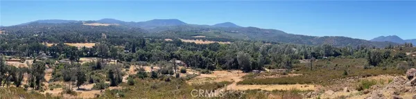 a view of a forest with mountains in the background