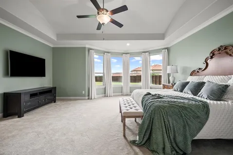 a large bedroom with a bed and flat screen tv