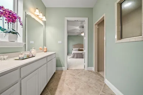 a bathroom with a sink vanity granite tub and a mirror