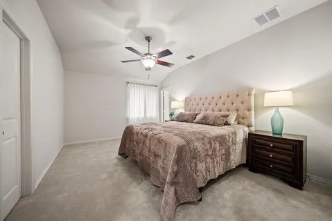 a spacious bedroom with a bed and a ceiling fan