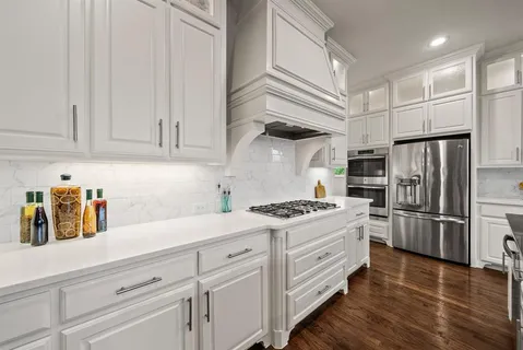 a kitchen with white cabinets and stainless steel appliances