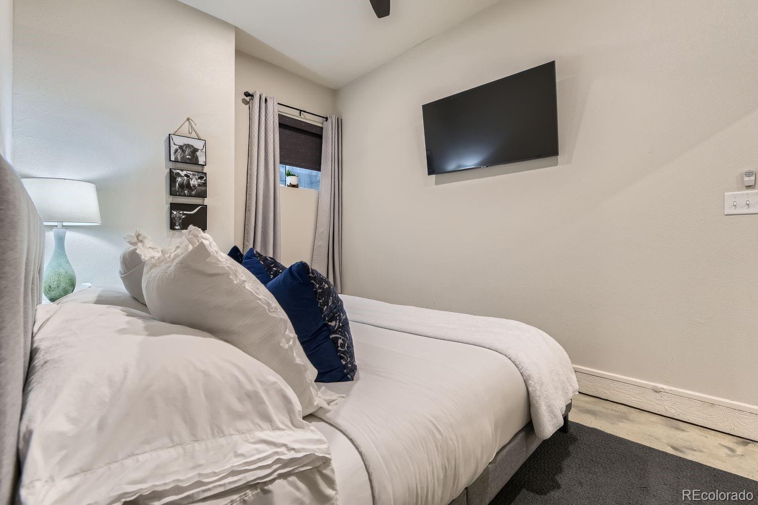 2132 North Nevada Avenue Colorado Springs, CO 80907 - Photo 17 of 26 a bedroom with a bed and a flat screen tv