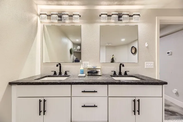 a bathroom with a granite countertop sink and a mirror