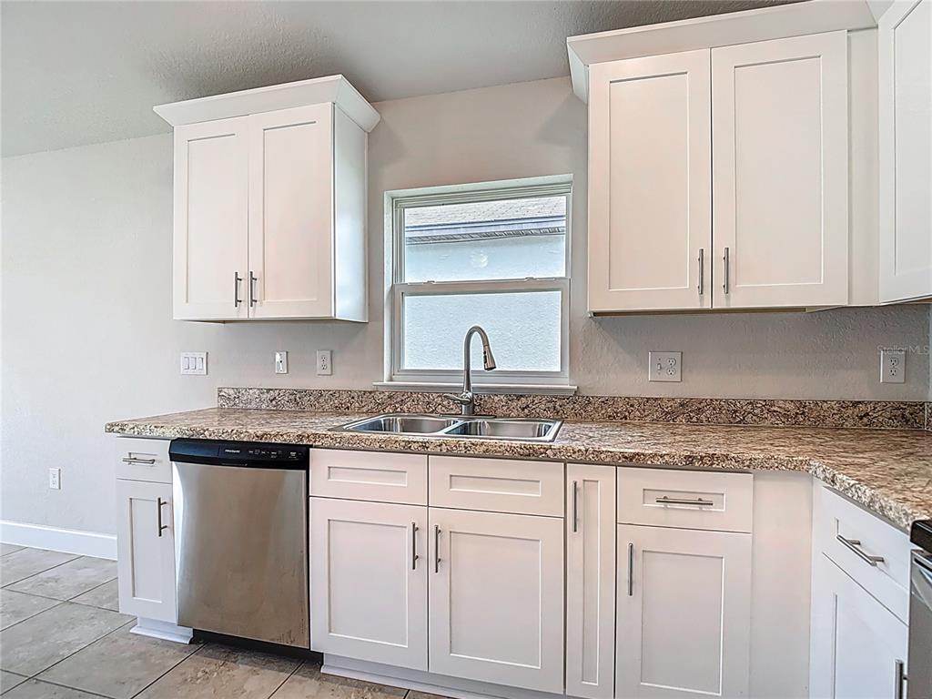 14917 Tropical Violet Way Wimauma, FL 33598 - Photo 17 of 77 a kitchen with white cabinets and sink