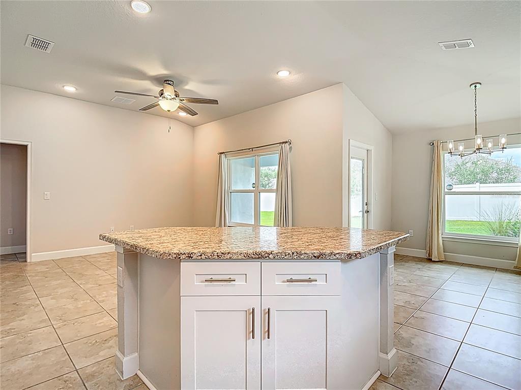 14917 Tropical Violet Way Wimauma, FL 33598 - Photo 18 of 77 a bathroom with a granite countertop sink a mirror and a vanity