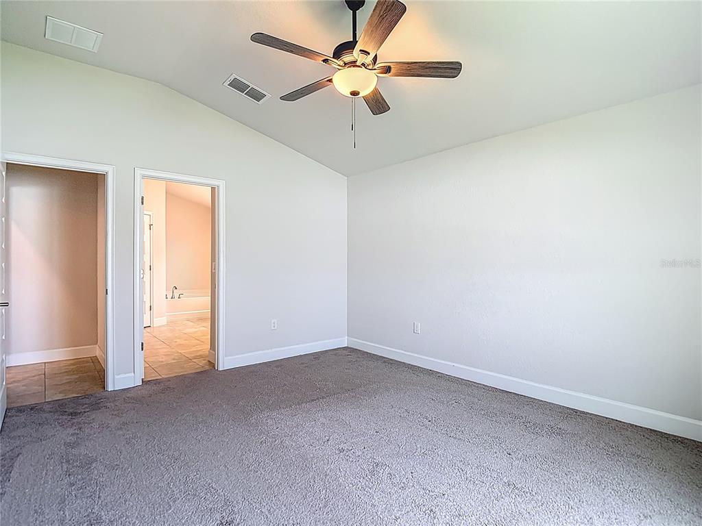 14917 Tropical Violet Way Wimauma, FL 33598 - Photo 27 of 77 an empty room with a ceiling fan and carpet