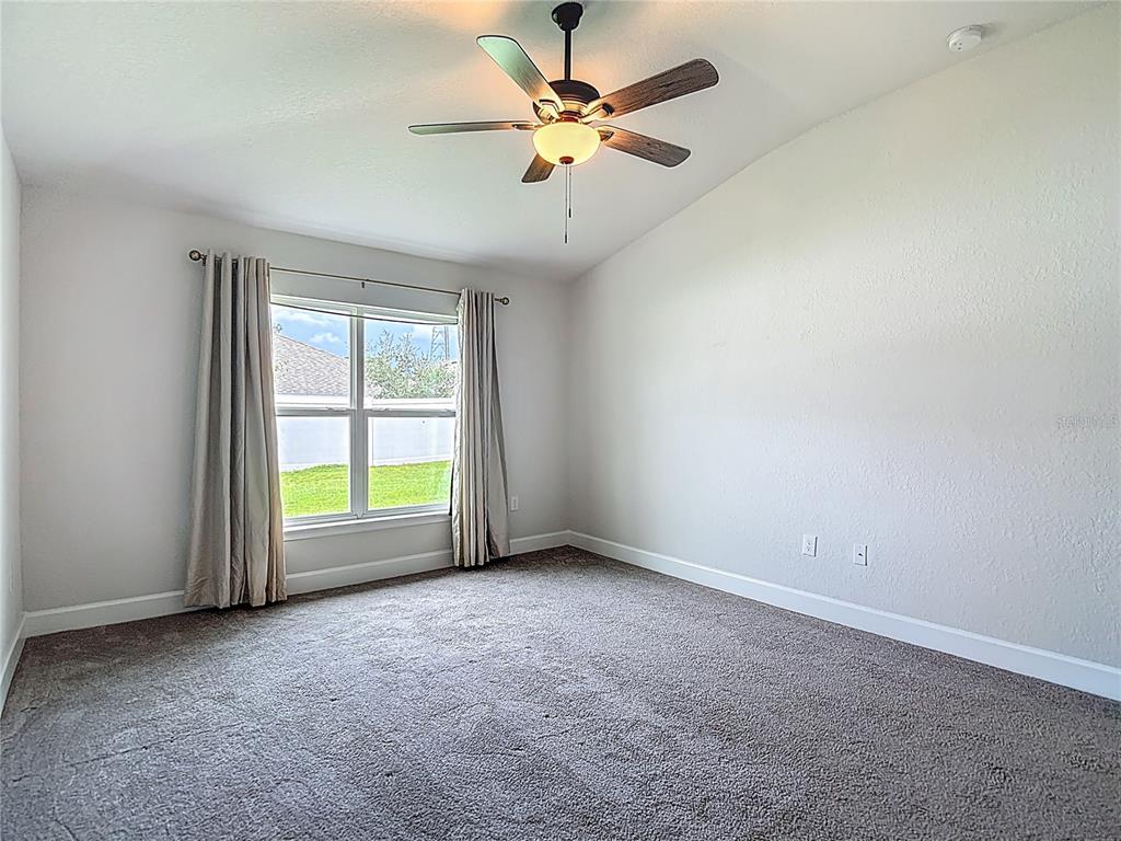 14917 Tropical Violet Way Wimauma, FL 33598 - Photo 29 of 77 an empty room with windows and fan