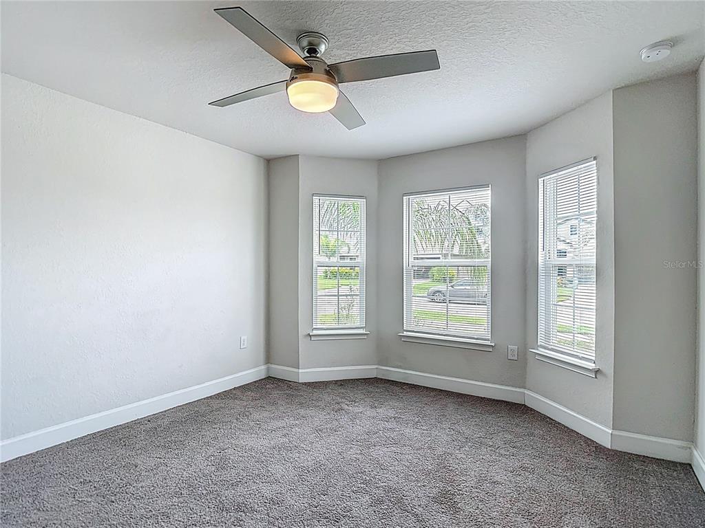14917 Tropical Violet Way Wimauma, FL 33598 - Photo 36 of 77 an empty room with windows and ceiling fan