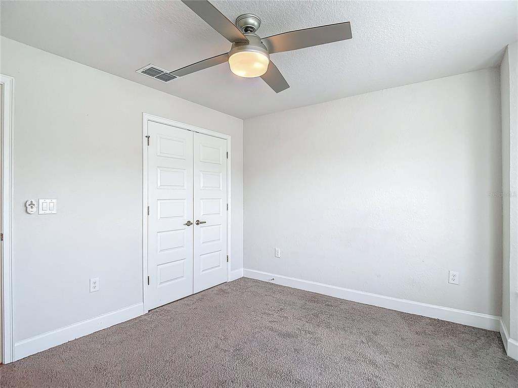 14917 Tropical Violet Way Wimauma, FL 33598 - Photo 37 of 77 an empty room with ceiling fan and window