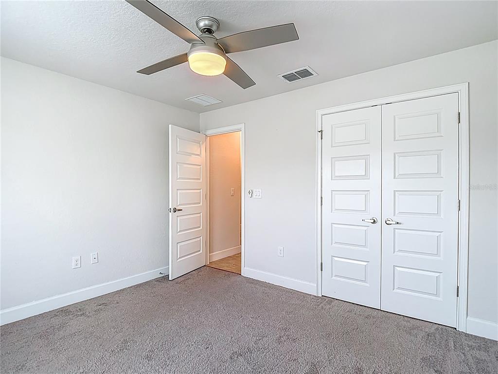 14917 Tropical Violet Way Wimauma, FL 33598 - Photo 38 of 77 an empty room with closet and fan