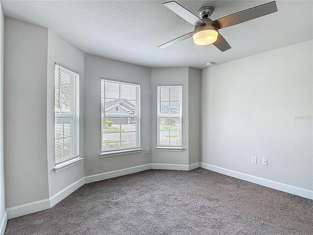 14917 Tropical Violet Way Wimauma, FL 33598 - Photo 39 of 77 an empty room with windows and fan
