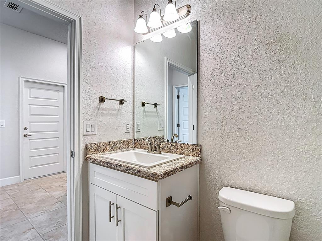 14917 Tropical Violet Way Wimauma, FL 33598 - Photo 41 of 77 a bathroom with a granite countertop sink and a mirror