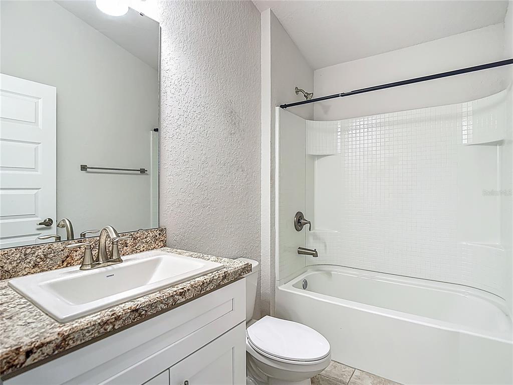 14917 Tropical Violet Way Wimauma, FL 33598 - Photo 42 of 77 a bathroom with a granite countertop sink toilet and shower