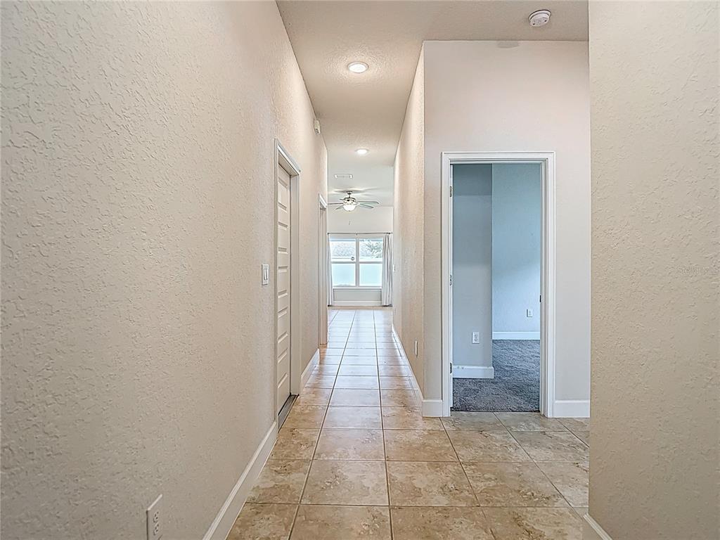 14917 Tropical Violet Way Wimauma, FL 33598 - Photo 9 of 77 a view of a hallway with wooden shelves