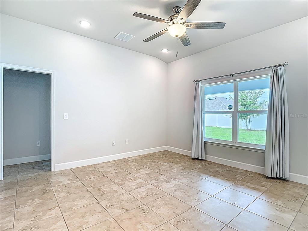 14917 Tropical Violet Way Wimauma, FL 33598 - Photo 10 of 77 an empty room with windows and fan