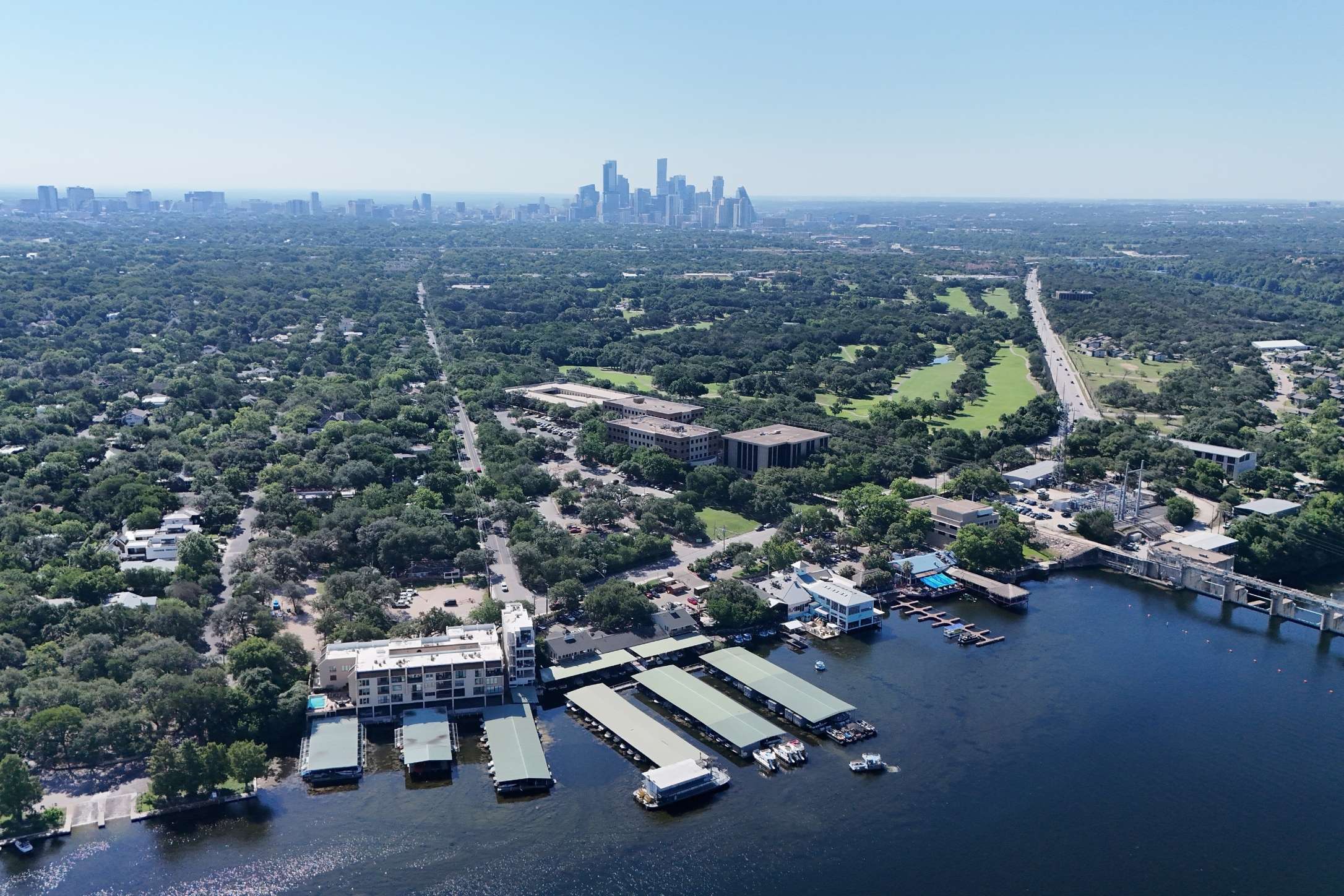 2208 Enfield Road, Unit 10500 Austin, TX 78703 - Photo 5 of 34 Elevated aerial perspective showcasing a substantial body of water with multiple boat slips, a bridge structure, and commercial buildings