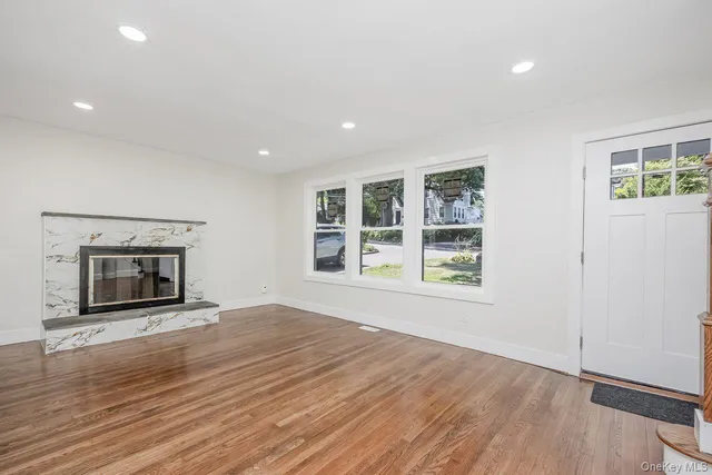an empty room with windows and fireplace