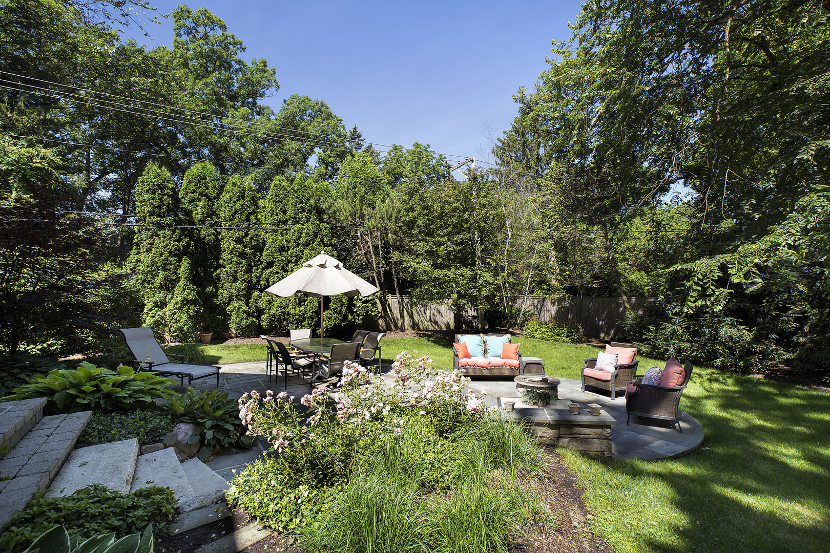 920 Bluff Street Glencoe, IL 60022 - Photo 27 of 29 a backyard of a house with table and chairs under an umbrella