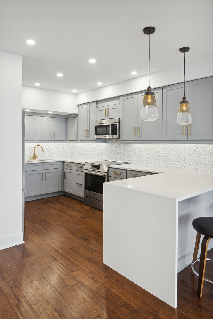 175 East Delaware Place, Unit 7204 Chicago, IL 60611 - Photo 8 of 30 a large kitchen with stainless steel appliances granite countertop a stove and a sink