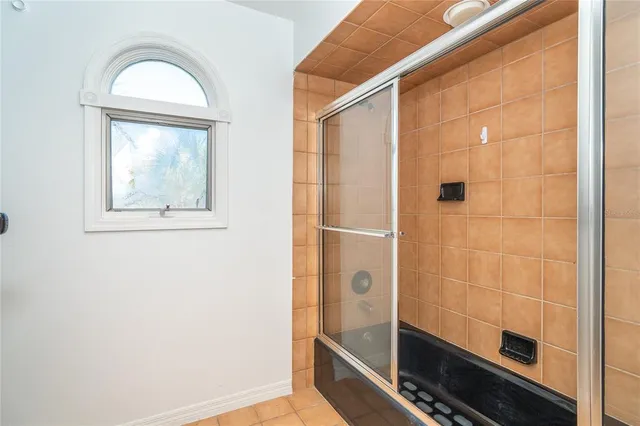 a bathroom with a glass door shower and a mirror