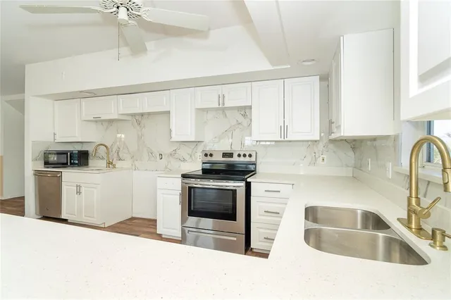 a kitchen with granite countertop a sink stainless steel appliances and cabinets