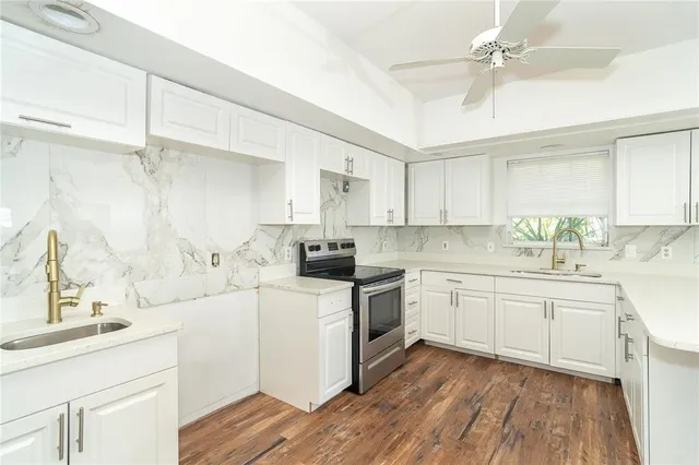 a kitchen with a sink cabinets stainless steel appliances and a window