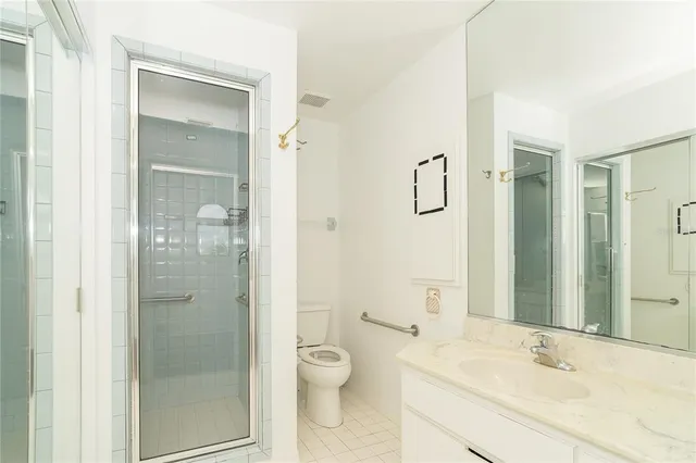 a bathroom with a granite countertop toilet sink and shower
