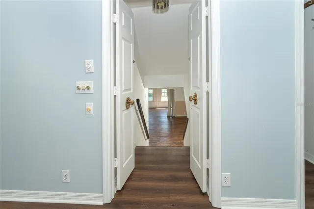 a view of a hallway with wooden floor and staircase