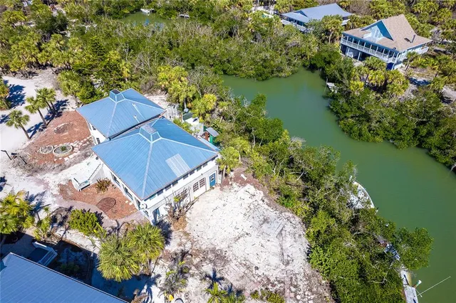 an aerial view of a house with a garden and lake view