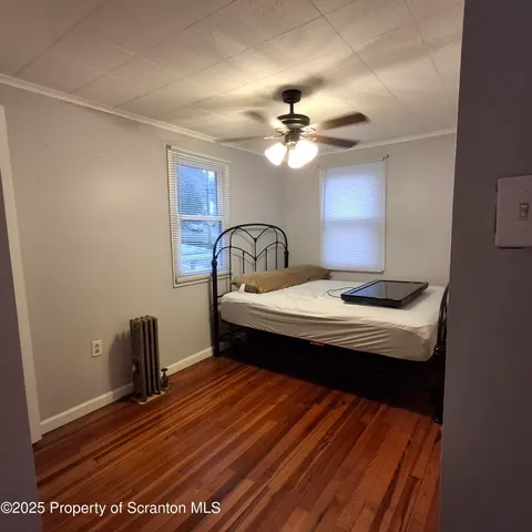 a bedroom with a bed and a ceiling fan