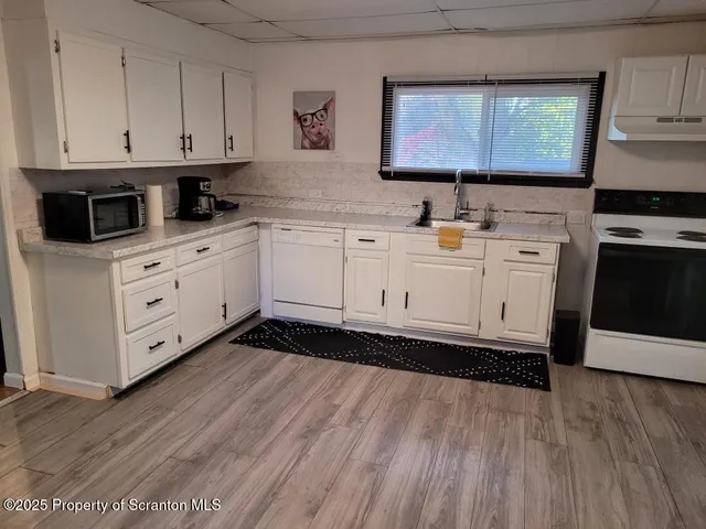 a kitchen with stainless steel appliances granite countertop a sink a stove and cabinets