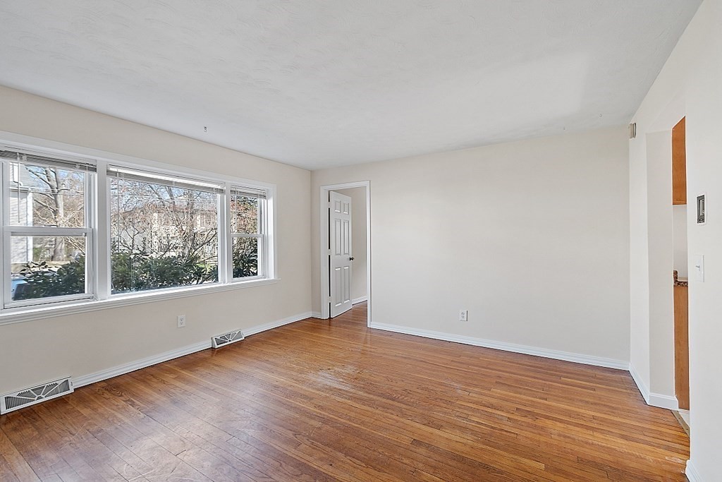 10 Vecchia Street, Unit C Webster, MA 01570 - Photo 2 of 29 a view of an empty room with wooden floor and a window