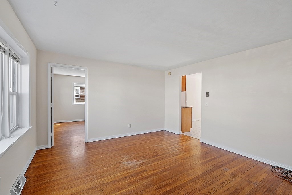 10 Vecchia Street, Unit C Webster, MA 01570 - Photo 4 of 29 a view of an empty room with wooden floor and a window