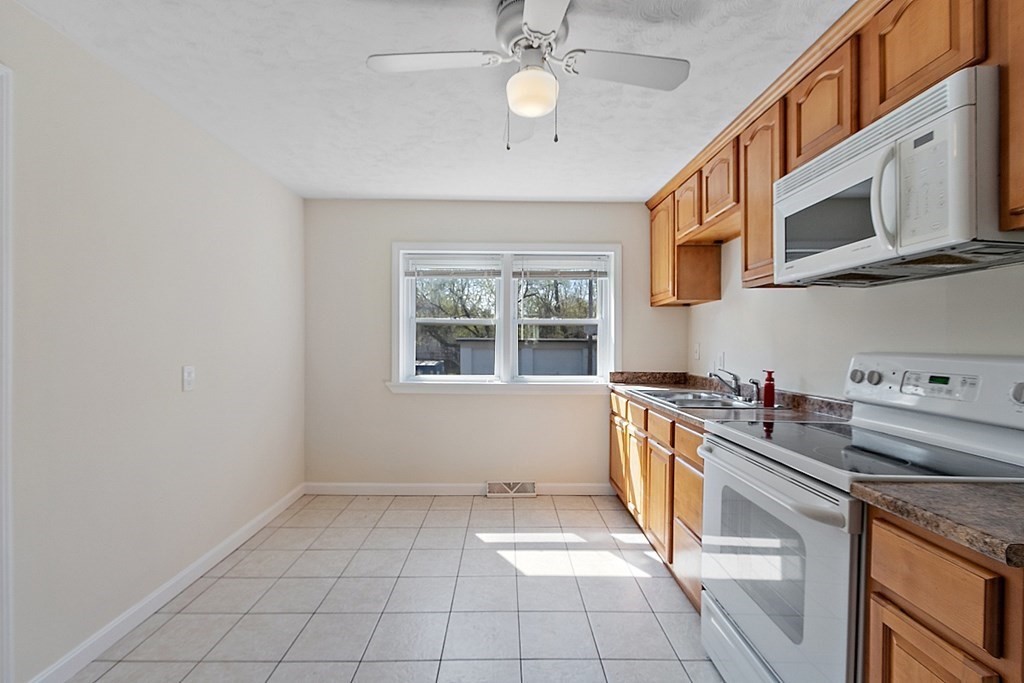 10 Vecchia Street, Unit C Webster, MA 01570 - Photo 6 of 29 a kitchen with stainless steel appliances a sink a stove a microwave and cabinets