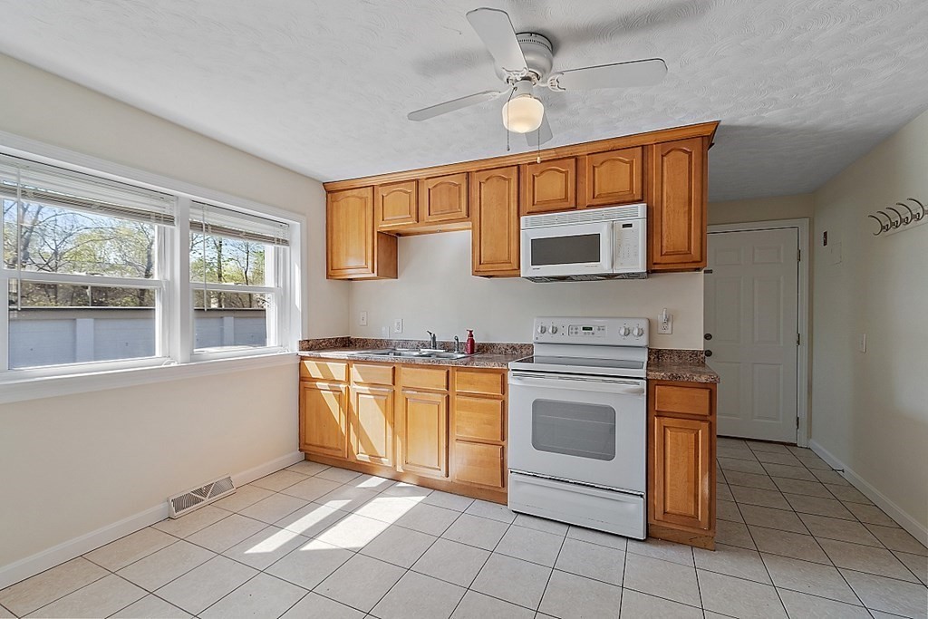 10 Vecchia Street, Unit C Webster, MA 01570 - Photo 7 of 29 a kitchen with stainless steel appliances granite countertop a stove a sink and a microwave