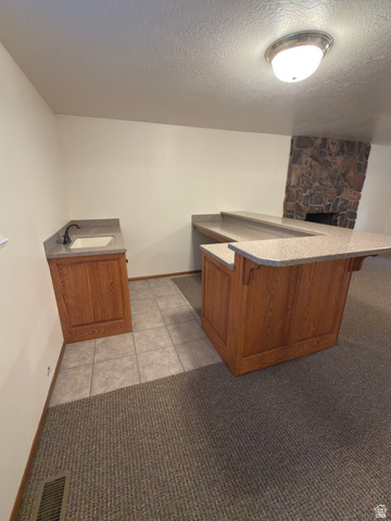 1164 East Mountain Road Logan, UT 84321 - Photo 19 of 45 Wet bar with wood cabinetry, light-toned countertop, and undermount sink