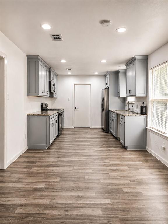 2908 Legend Road Arlington, TX 76014 - Photo 9 of 29 Bright, open kitchen featuring modern gray cabinetry, stainless steel appliances, and plenty of space to cook, gather, and entertain!