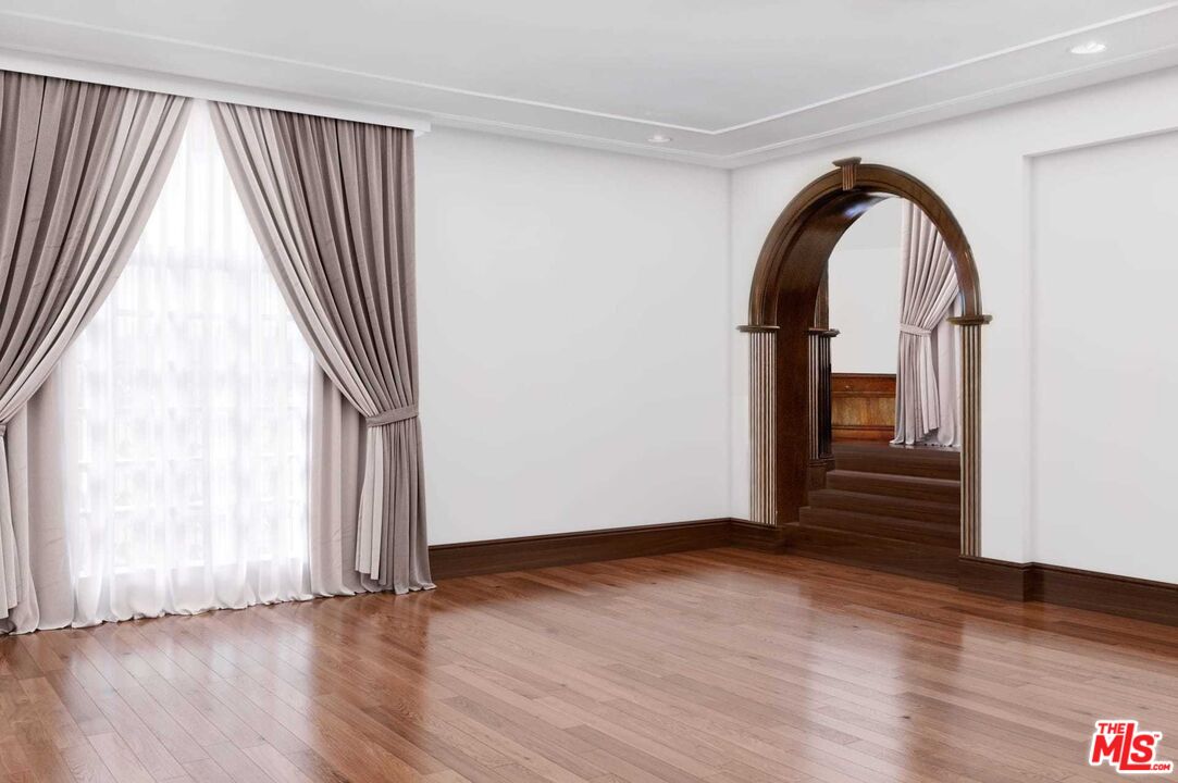 25045 Jim Bridger Road Hidden Hills, CA 91302 - Photo 18 of 52 an empty room with wooden floor and windows