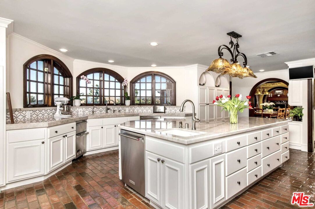 25045 Jim Bridger Road Hidden Hills, CA 91302 - Photo 21 of 52 a kitchen with granite countertop a white cabinets and chandelier