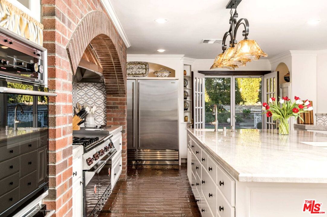 25045 Jim Bridger Road Hidden Hills, CA 91302 - Photo 22 of 52 a kitchen with stainless steel appliances granite countertop a stove and a chandelier
