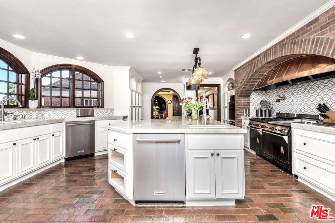 25045 Jim Bridger Road Hidden Hills, CA 91302 - Photo 23 of 52 a kitchen with stainless steel appliances granite countertop a stove a sink dishwasher and cabinets with wooden floor