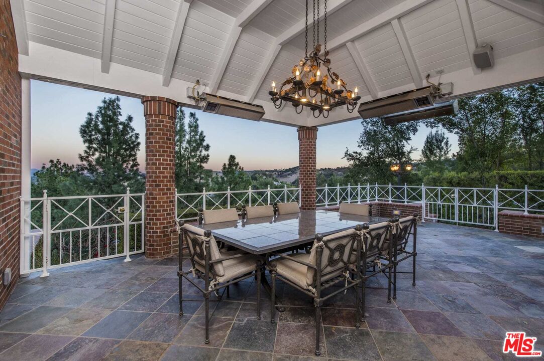25045 Jim Bridger Road Hidden Hills, CA 91302 - Photo 36 of 52 a view of a roof deck with table and chairs with wooden floor