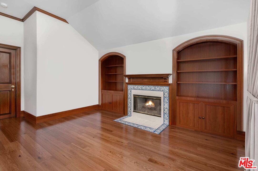 25045 Jim Bridger Road Hidden Hills, CA 91302 - Photo 38 of 52 a view of an empty room with wooden floor and a fireplace