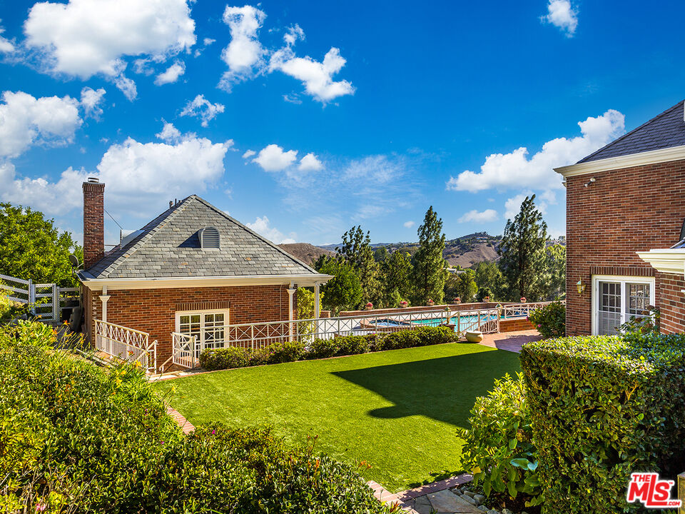 25045 Jim Bridger Road Hidden Hills, CA 91302 - Photo 4 of 52 a front view of a house with a garden and plants