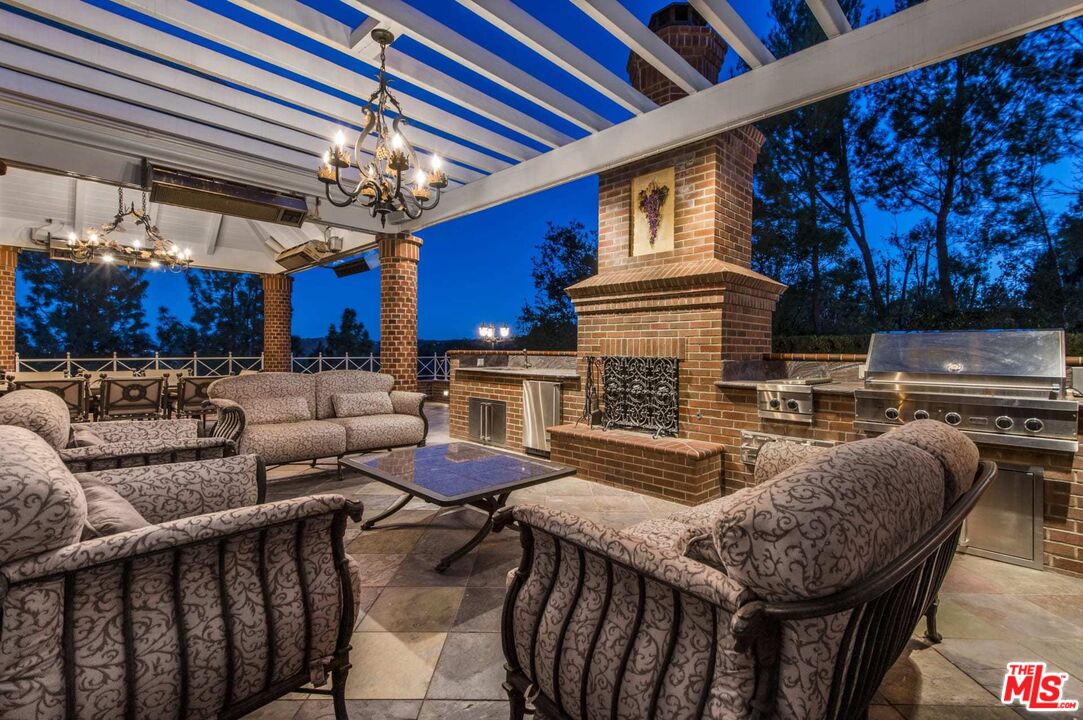 25045 Jim Bridger Road Hidden Hills, CA 91302 - Photo 41 of 52 a outdoor living space with furniture and a fireplace