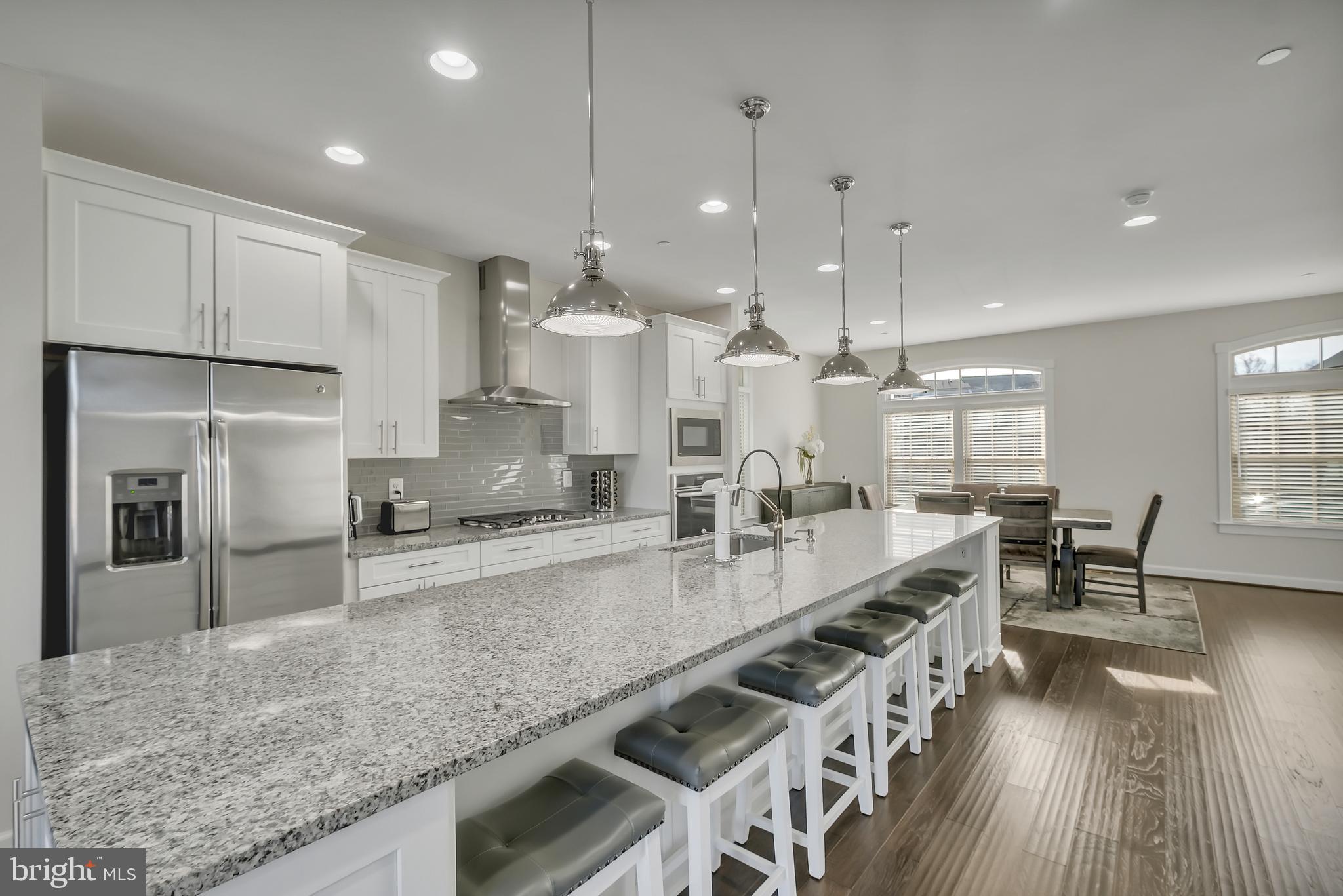 2918 Middleham Court Hanover, MD 21076 - Photo 2 of 37 a large kitchen with kitchen island a large counter top space a sink stainless steel appliances and cabinets
