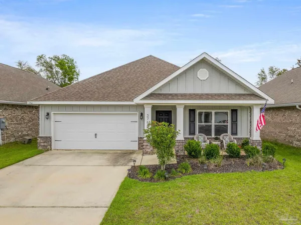 a front view of a house with a yard and potted plants