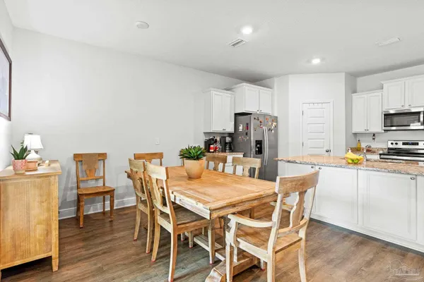 a view of kitchen with refrigerator stove dining table and chairs